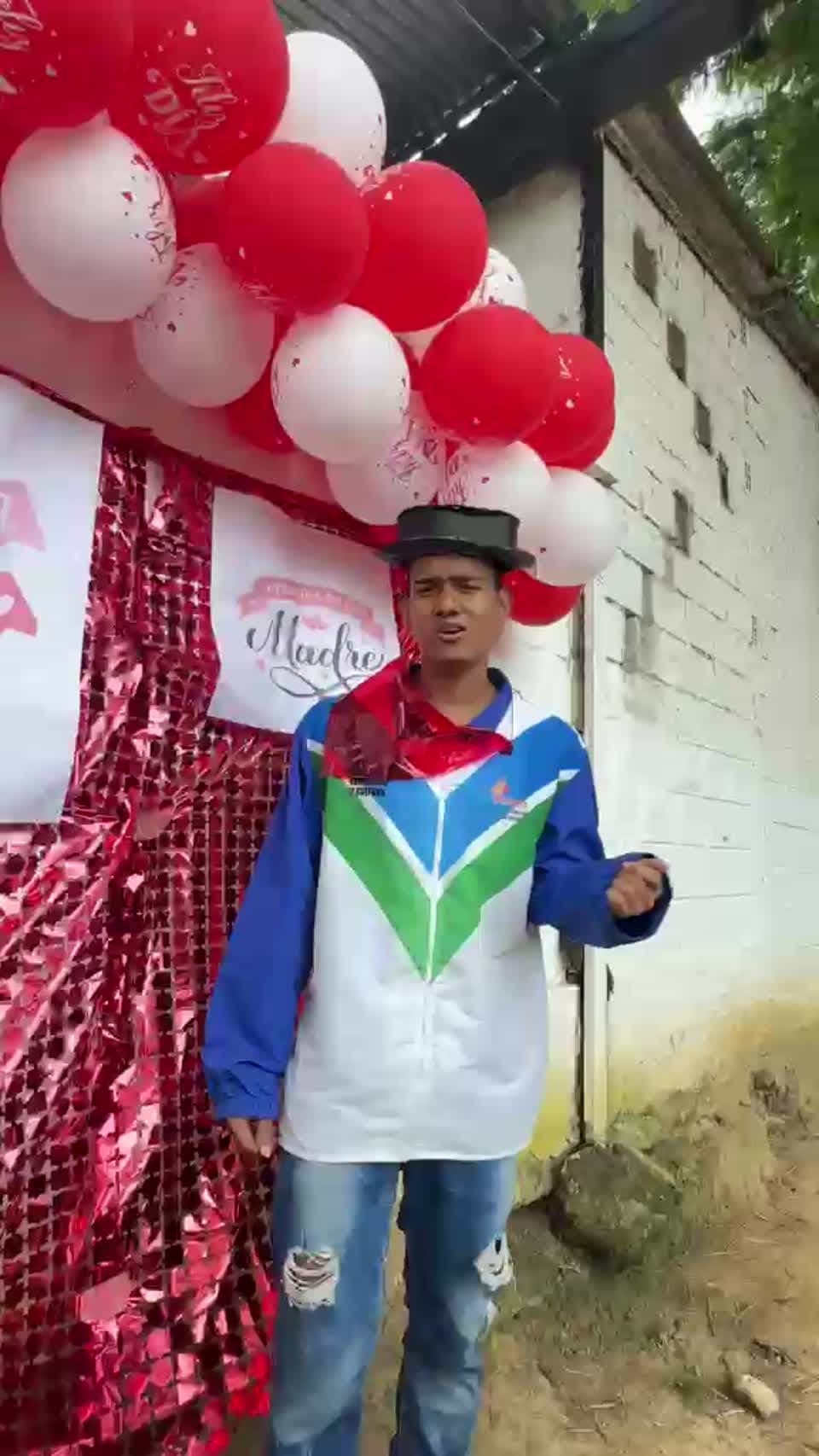 Participante con sombrero frente a decoración del Día de la Madre