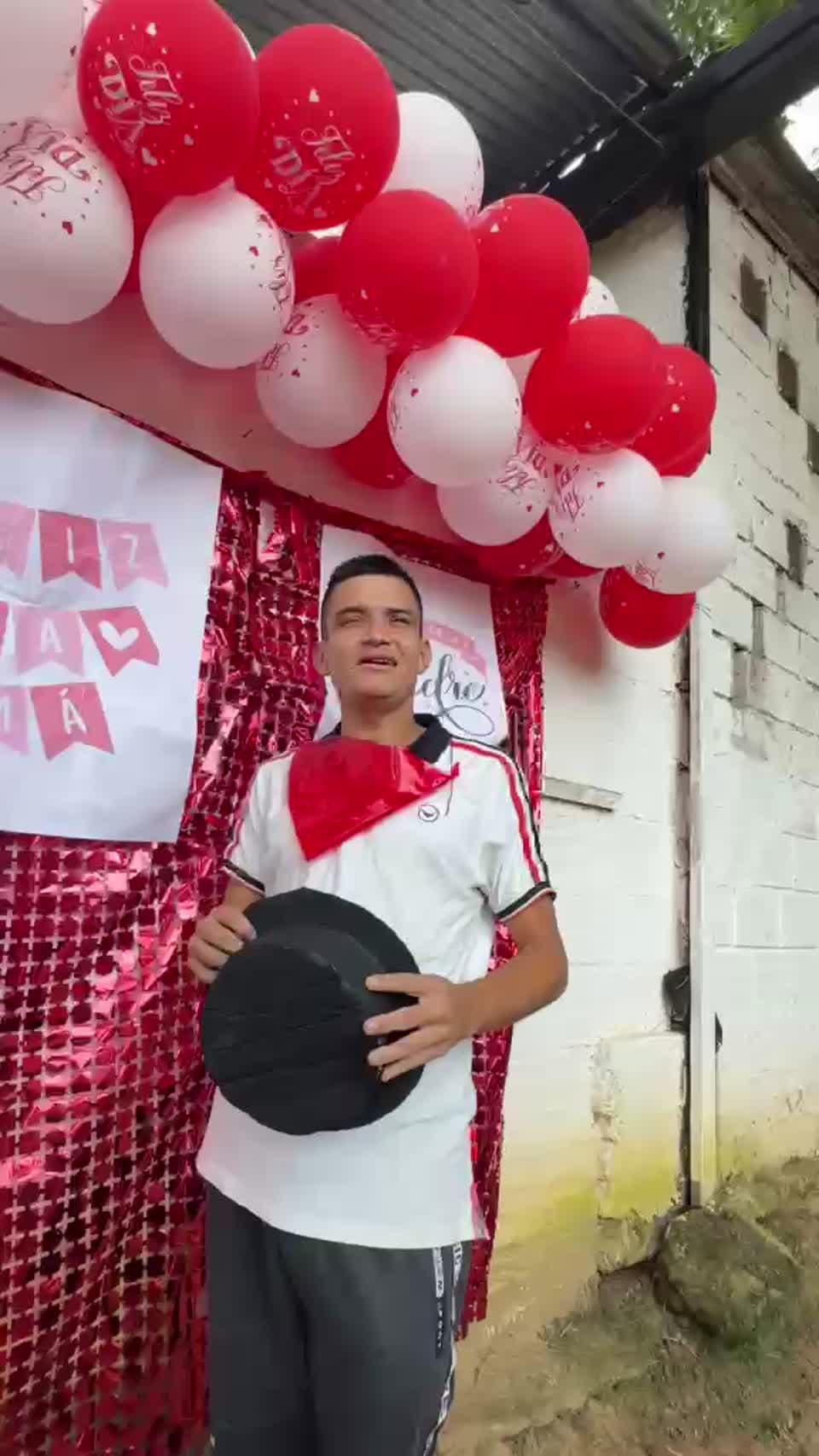 Participante con sombrero frente a decoración del Día de la Madre